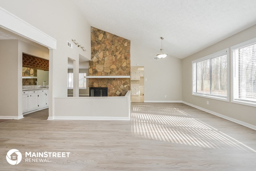an empty living room with a fireplace and a large window