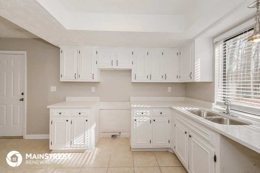 a large white kitchen with white cabinets and a sink