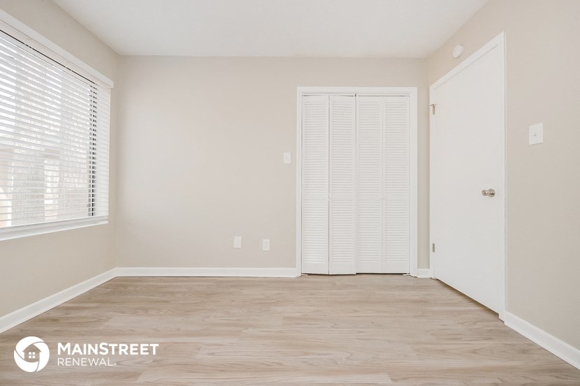 the living room of a home with a wood floor and a closet