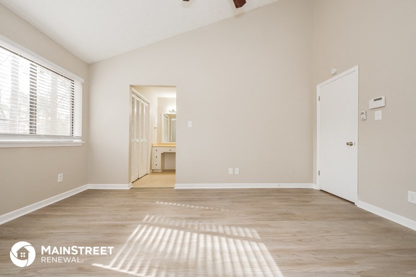 a spacious living room with a door to the bathroom