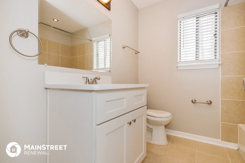 a bathroom with a sink toilet and a mirror