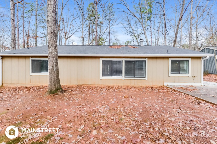 the front of a house with a yard and a tree