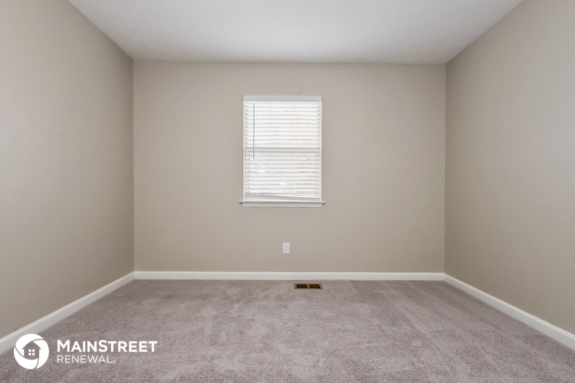 the upstairs bedroom with carpet and a window