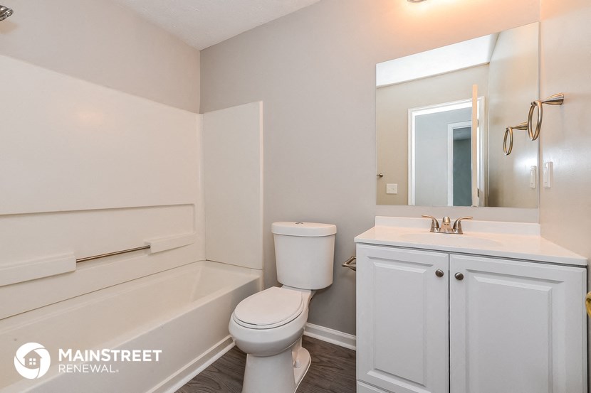 a bathroom with a toilet and a sink and a bath tub