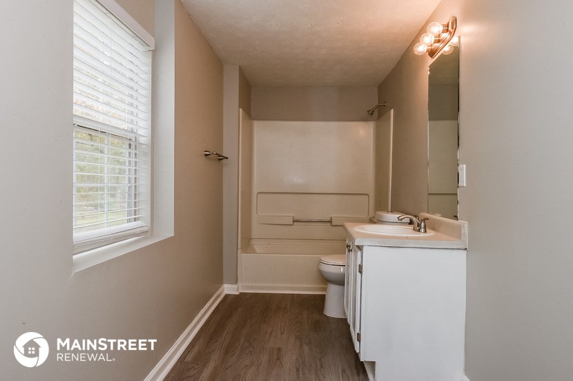 a bathroom with a toilet and a sink and a window