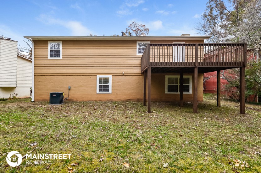 the back of a house with a deck on top of it