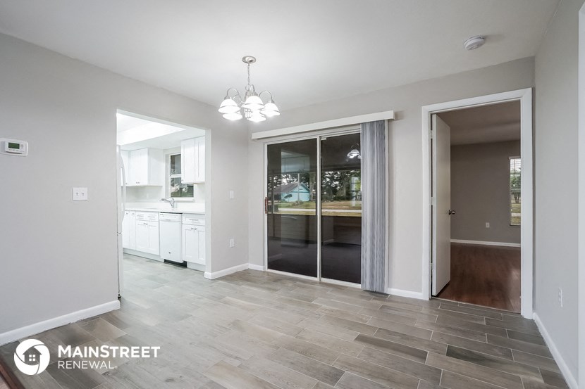 an open kitchen and dining room with a sliding glass door