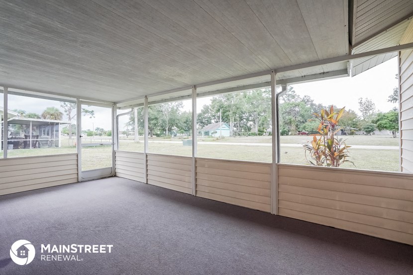 the screened porch of a manufactured home with large glass windows
