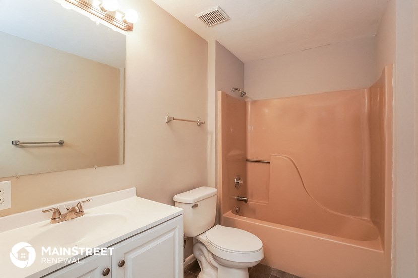 a bathroom with a toilet and a tub and a sink