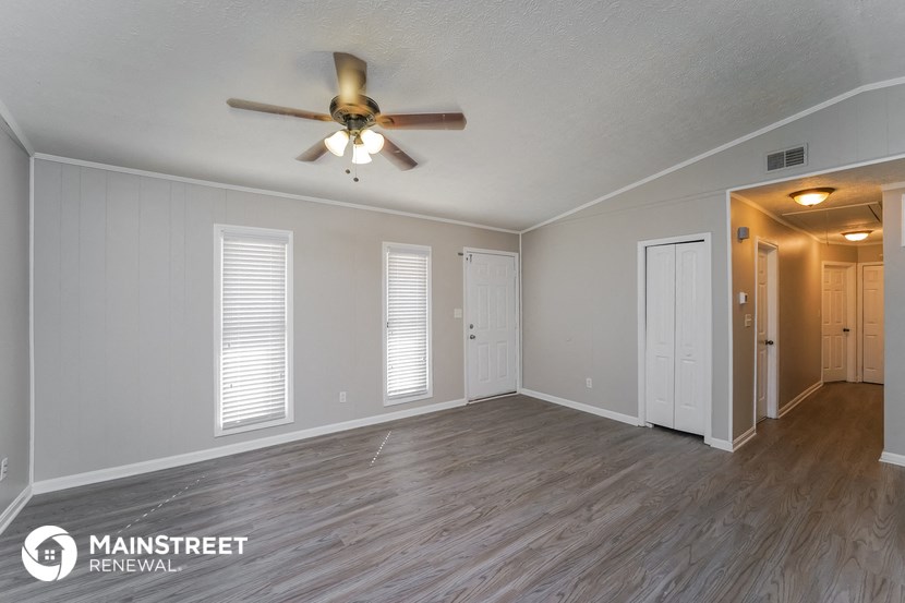 the living room of an empty house with a ceiling fan