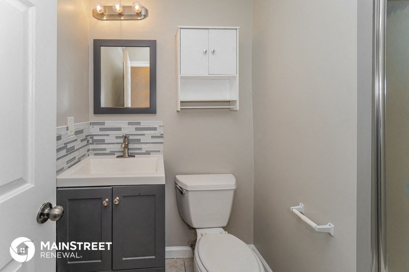 a bathroom with a toilet and a sink and a mirror
