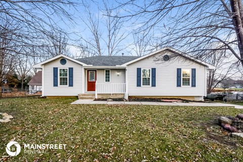 a small white house with green shutters and a red door