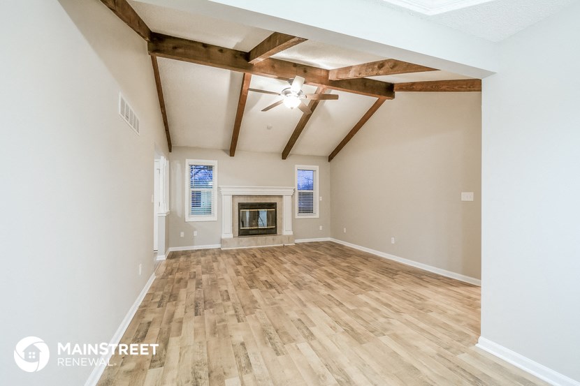 the great room with wood floors and a fireplace