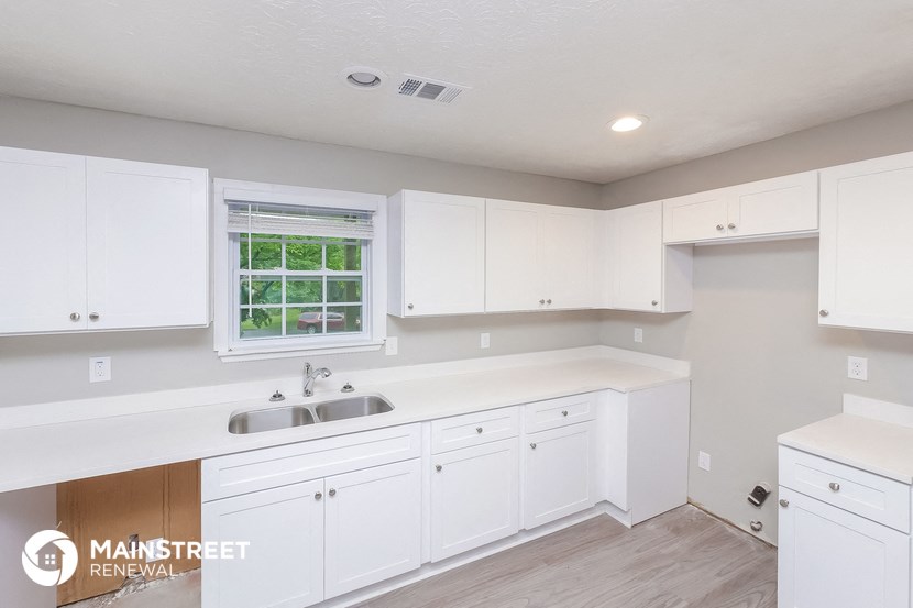 a white kitchen with white cabinets and a sink