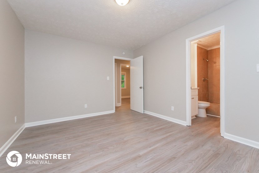 the living room and dining room of an apartment with wood flooring