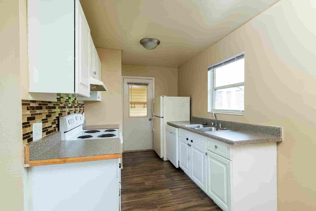 a kitchen with white cabinets and a sink and a refrigerator