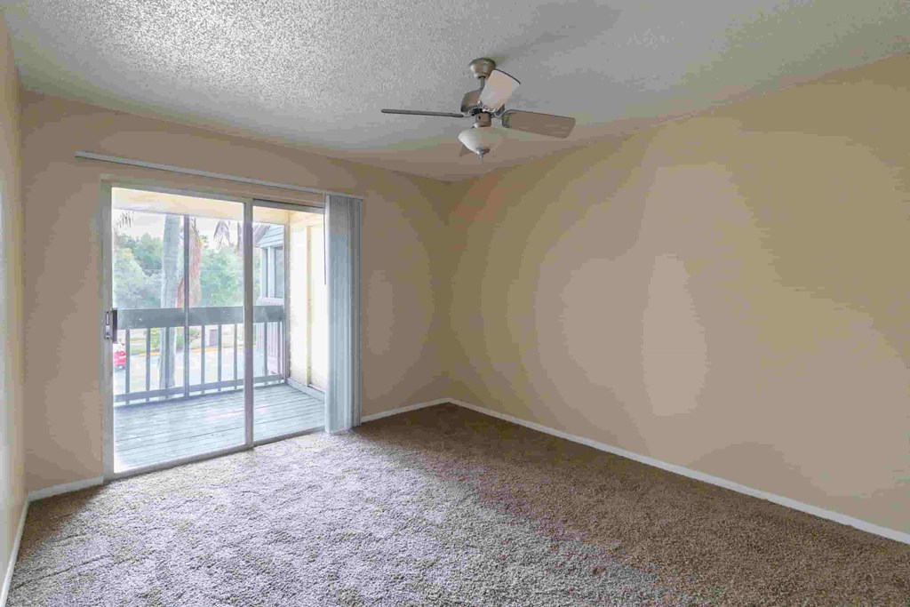 an empty living room with a ceiling fan
