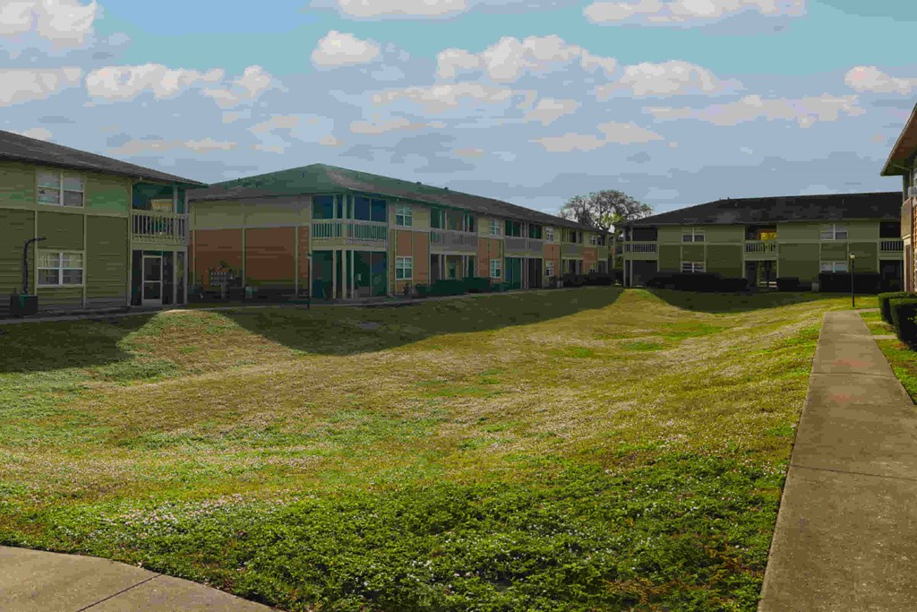 a row of houses on a grass yard with a sidewalk