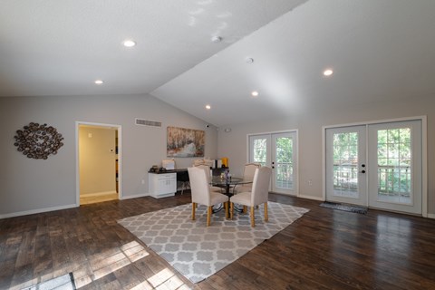A dining room with a table set for four.