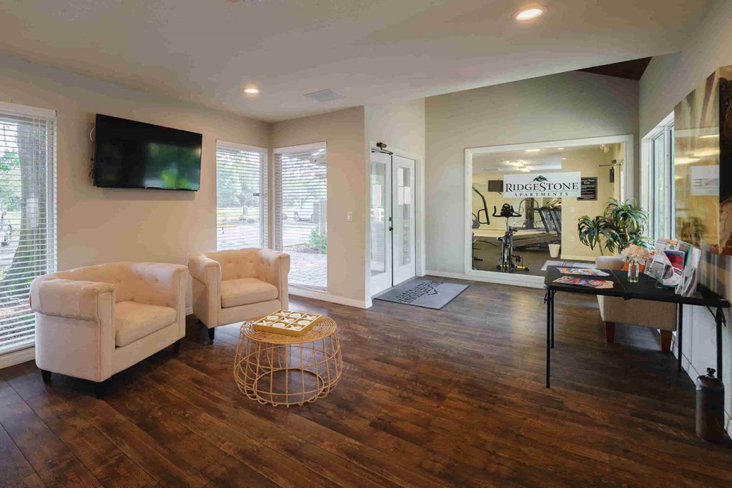 a living room with two chairs and a table and a television