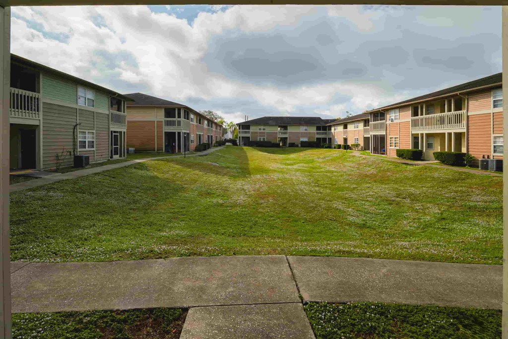 a row of houses on a green lawn with grass
