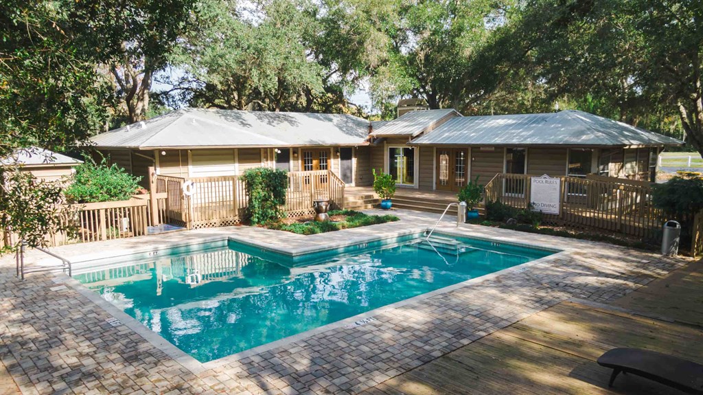 a swimming pool in front of a house with a pool