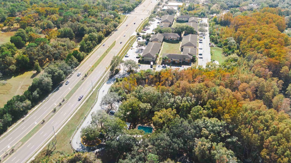 an aerial view of a city with a highway and trees