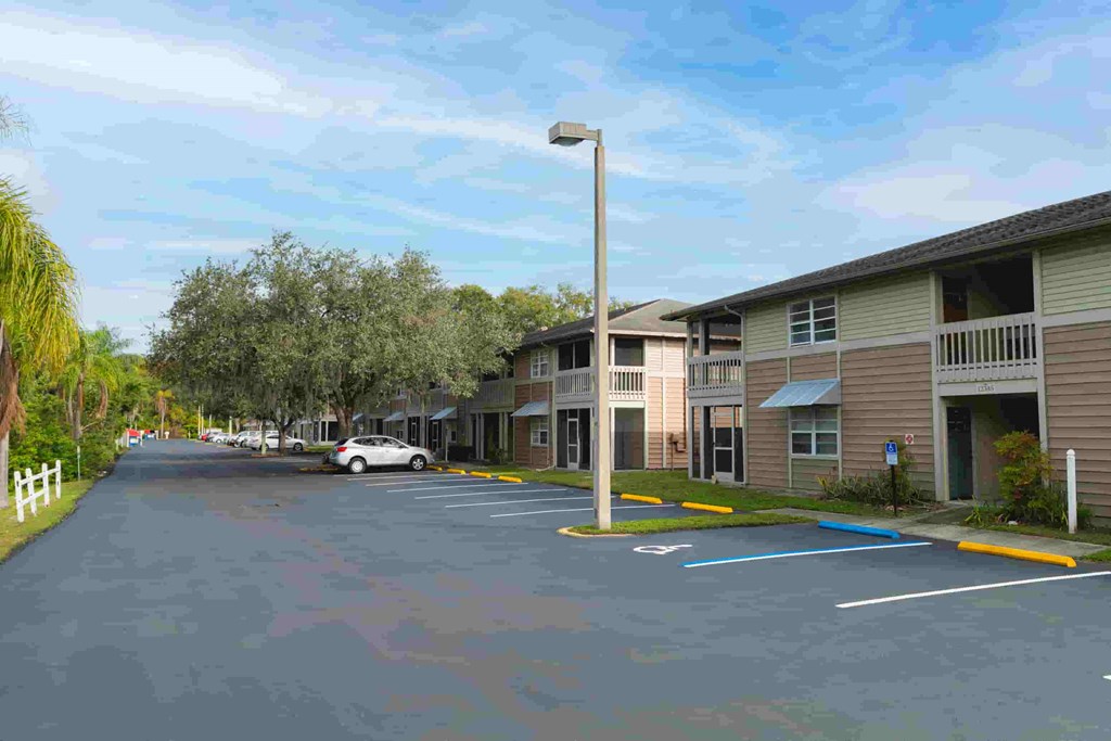 an empty parking lot in front of a row of apartment buildings