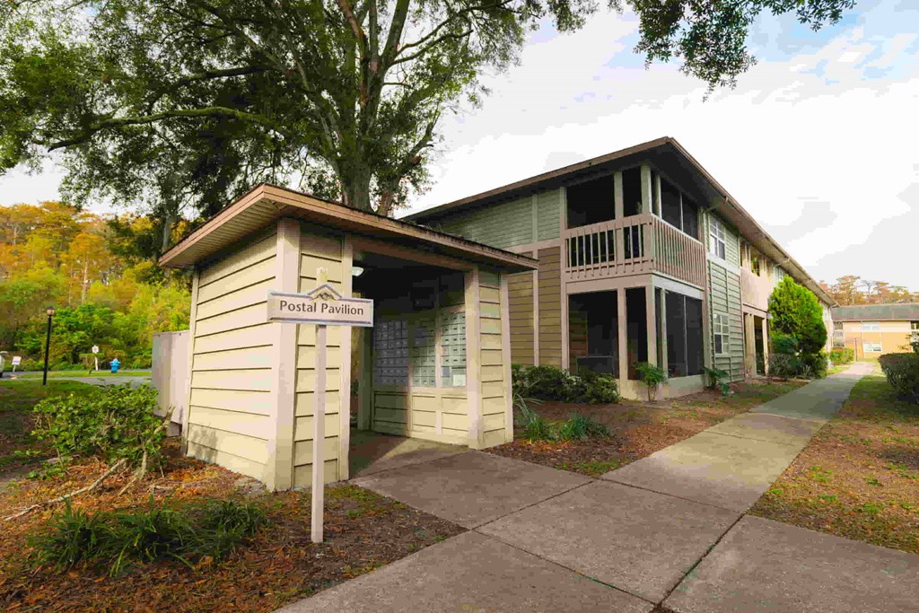 a small building with a sign on the sidewalk in front of it
