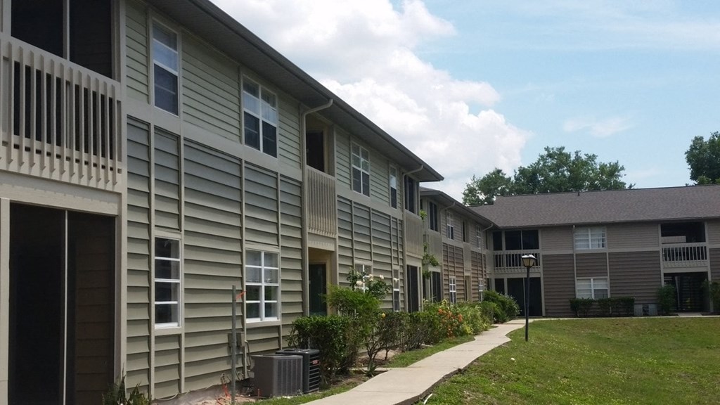 an exterior view of an apartment building with a sidewalk