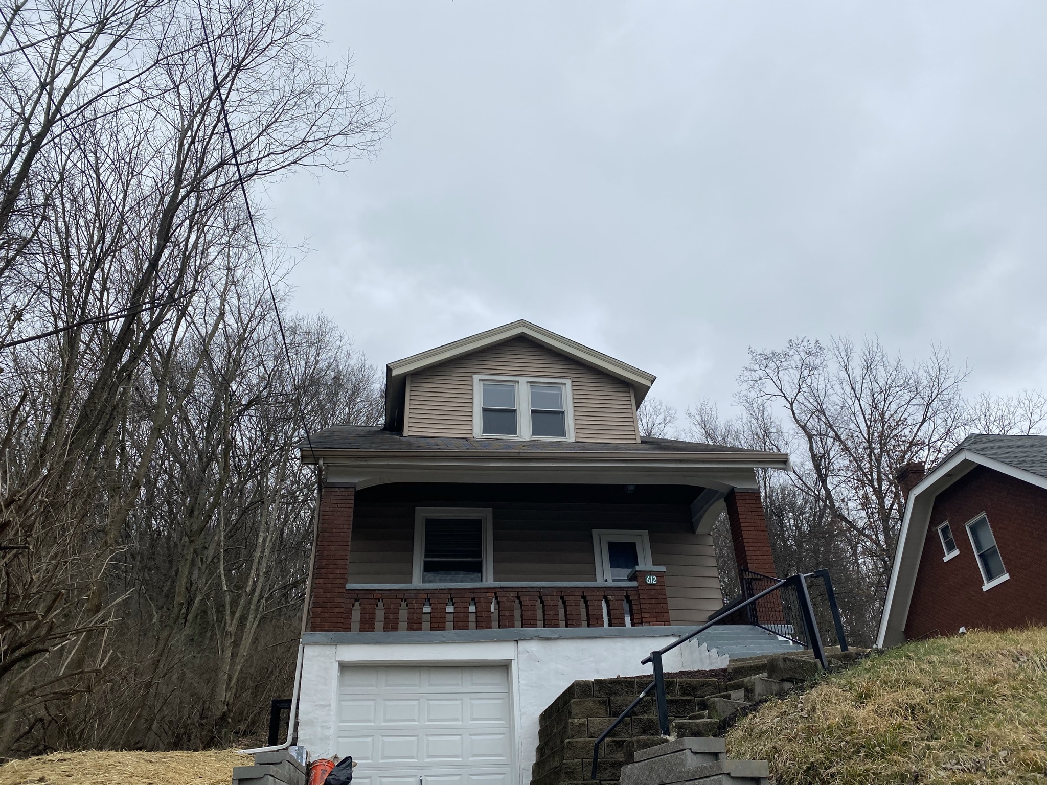 a home with a white garage door and a brown house
