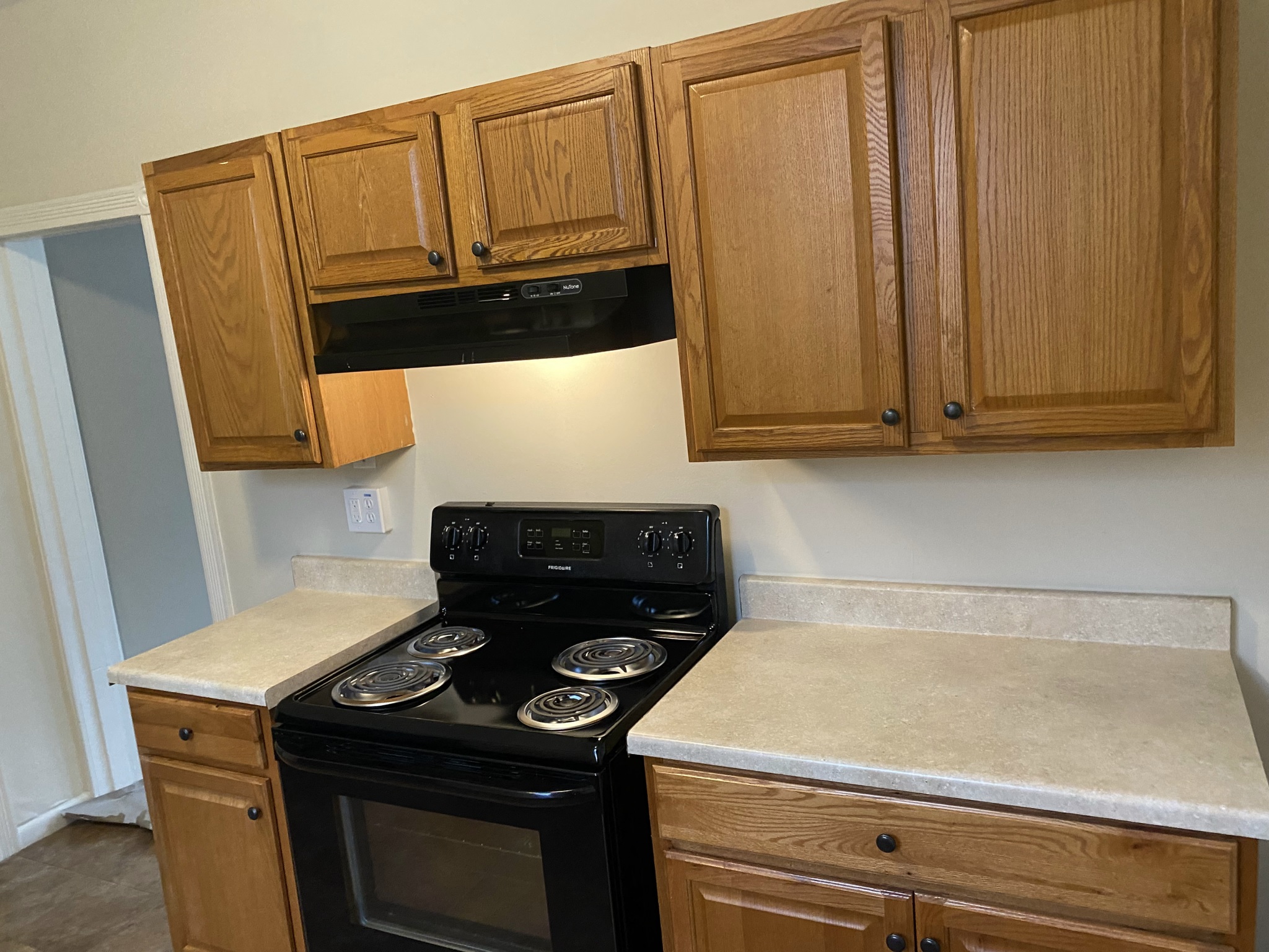 a kitchen with wooden cabinets and a stove and a microwave