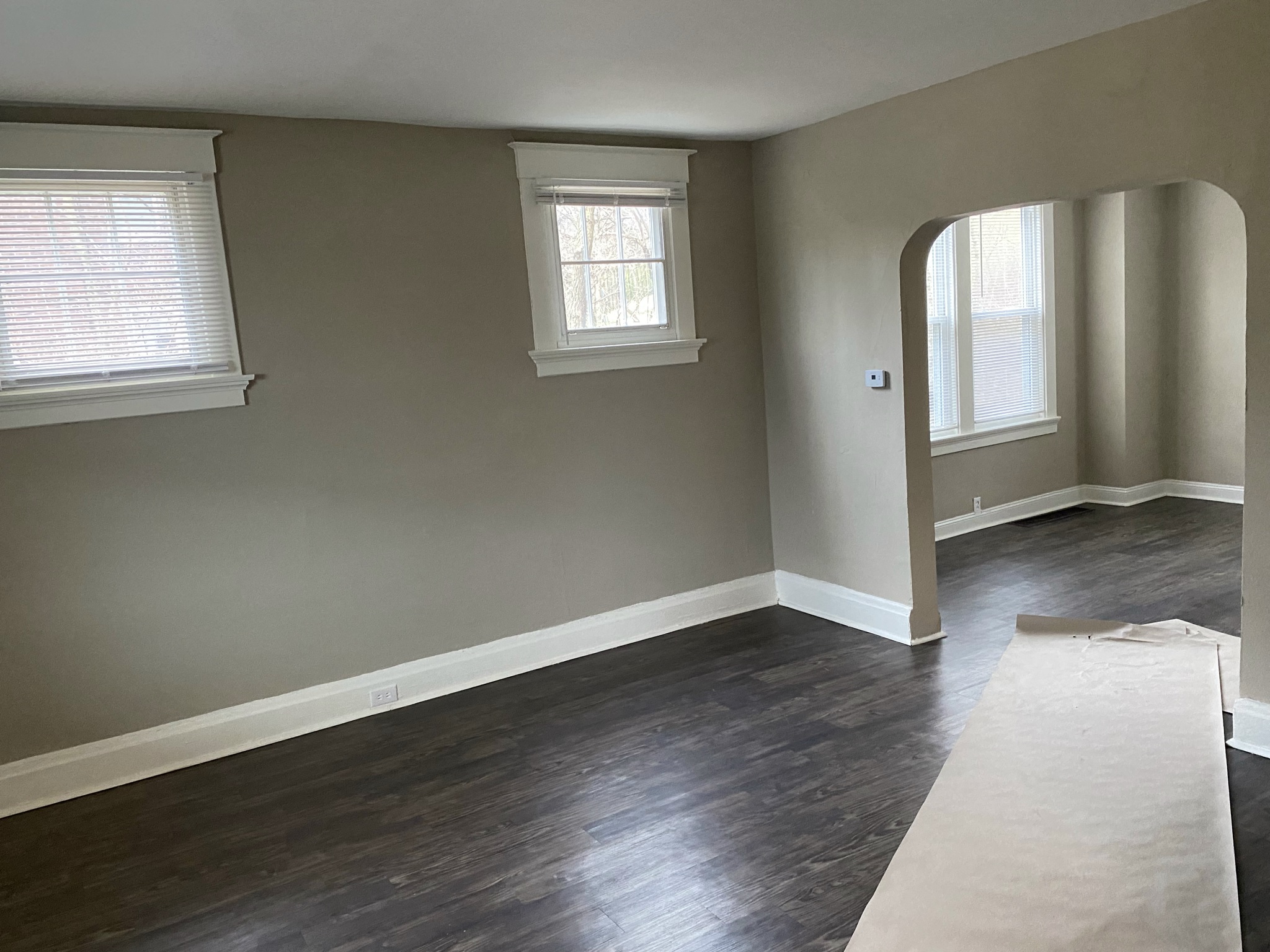 an empty living room with wood floors and gray walls