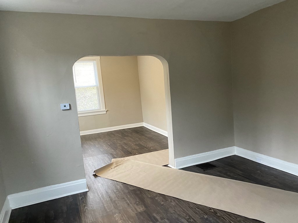 an empty room with a sheet of plywood on the floor and a window