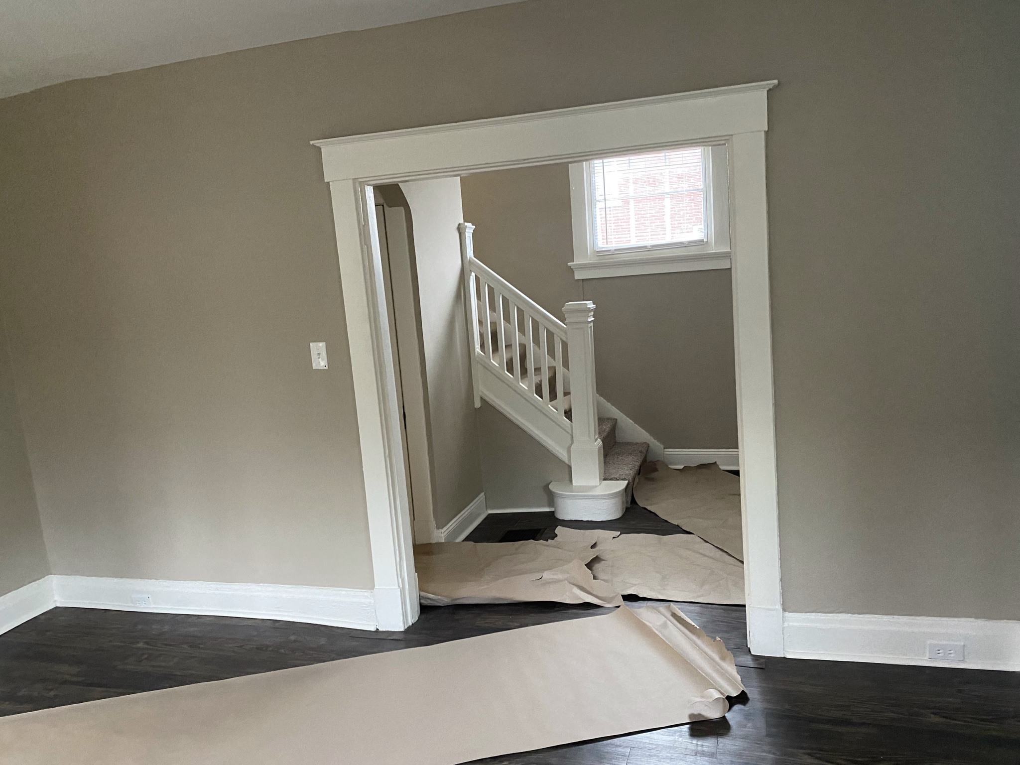 a stairwell in a room with paper on the floor and a staircase with a