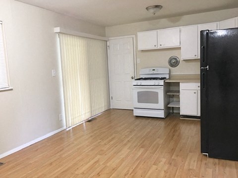 an empty kitchen with a stove and a refrigerator