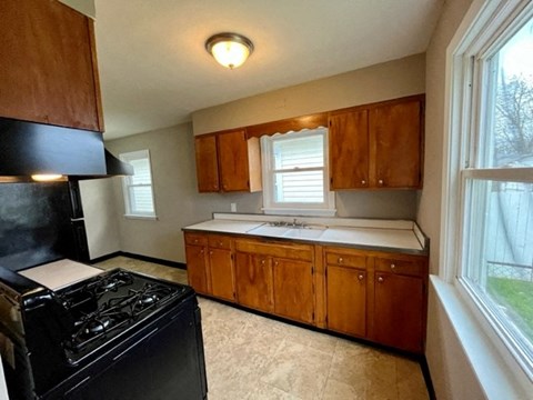 a kitchen with a black refrigerator and a window
