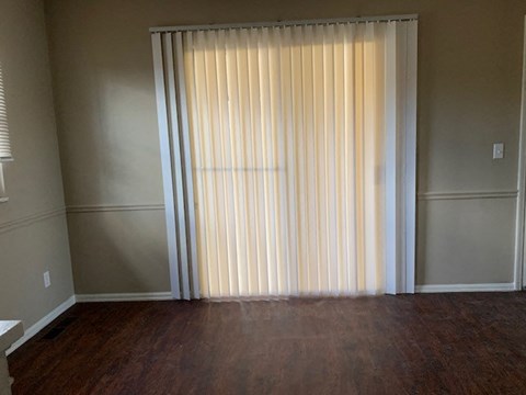 A room with a window covered by a sheer curtain.