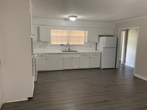 A kitchen with white appliances and cabinets.