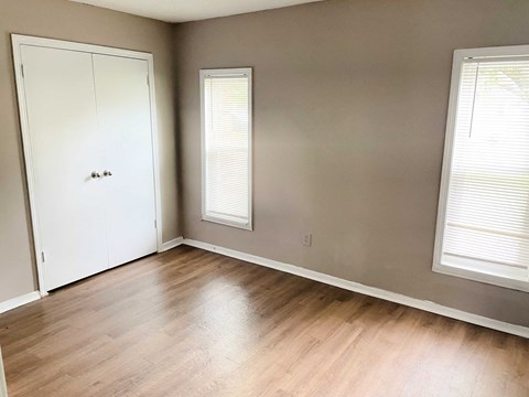 a living room with wood floors and a white door