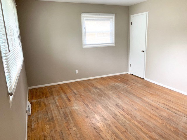 a empty room with a wooden floor and a window