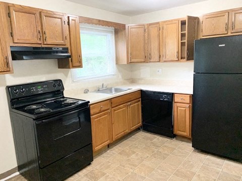 a kitchen with black appliances and wooden cabinets