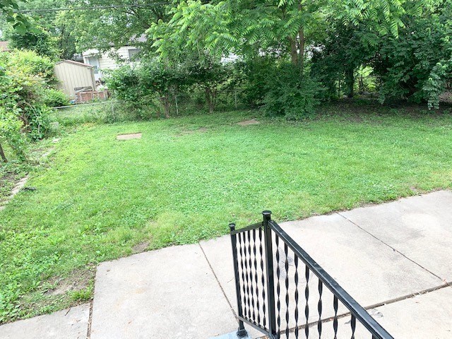 a backyard with a fence and a yard with grass and trees