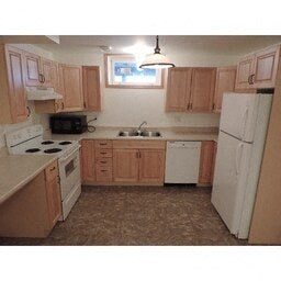 A kitchen with wooden cabinets and white appliances.