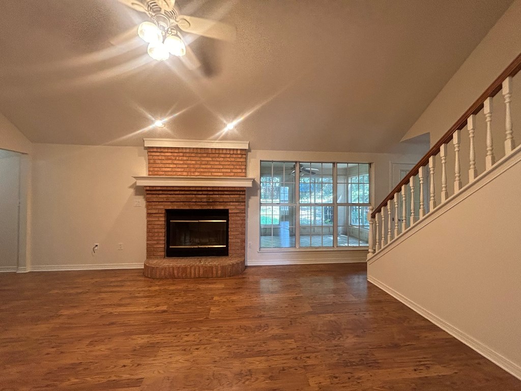 A room with a fireplace and a ceiling fan.