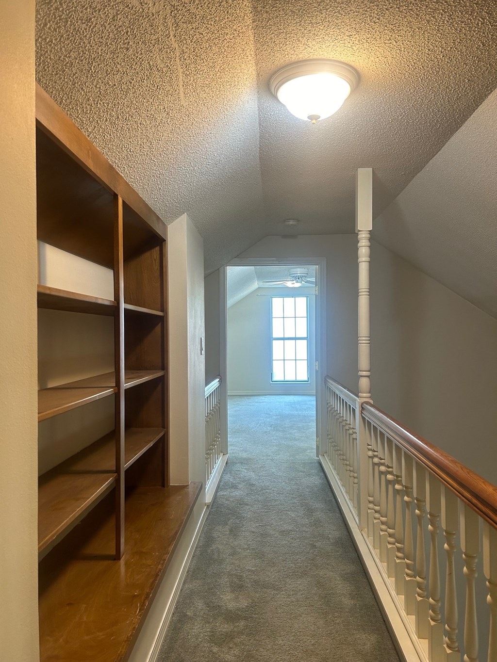 A long hallway with a window at the end.