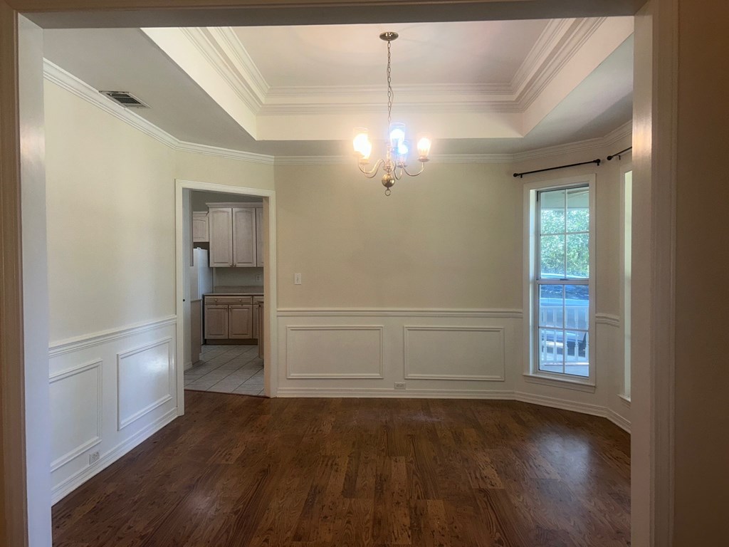 A room with wooden floors and a chandelier.