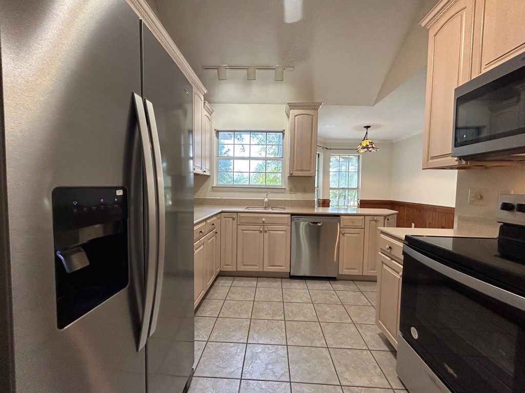 A kitchen with a stainless steel refrigerator and black oven.