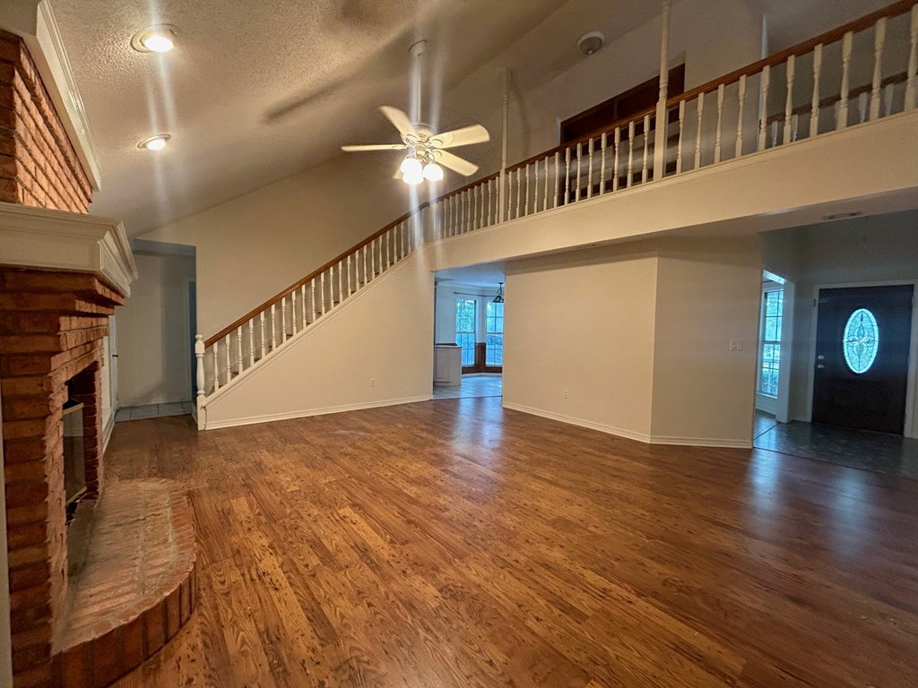 A large open room with a staircase and a ceiling fan.
