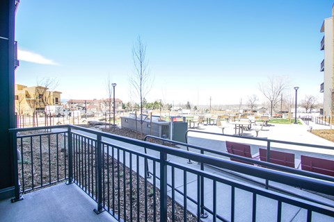a balcony with a view of a yard and a building